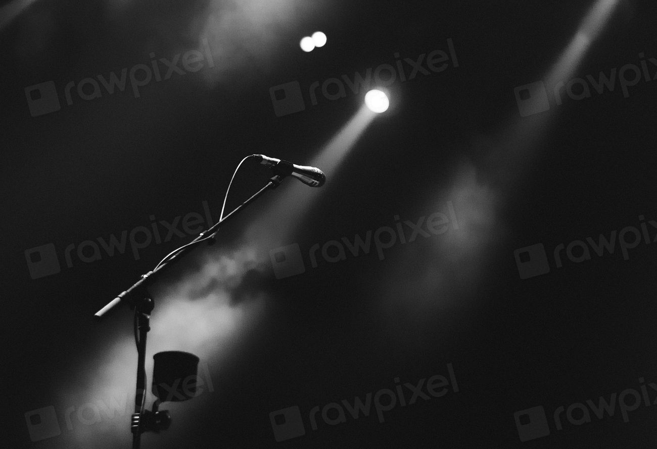 A microphone on a stand under a single stage light